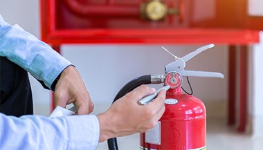 person checking date on a fire estinguisher