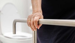 Old woman holding onto a safety rail