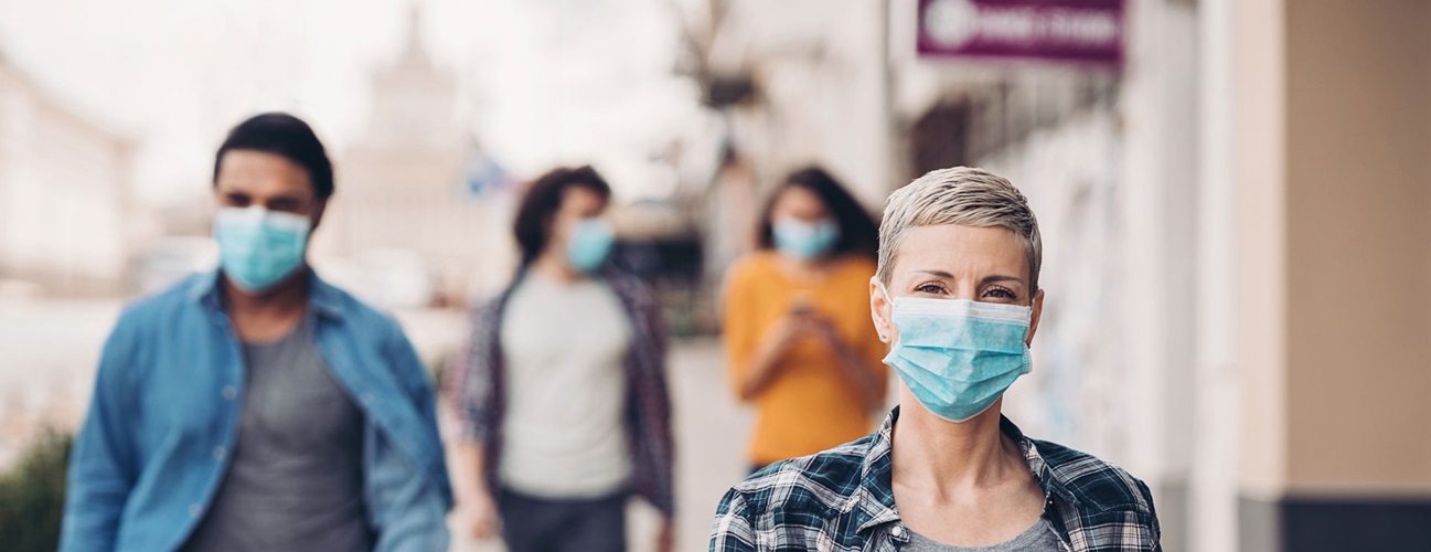 People walking the street with protective face coverings