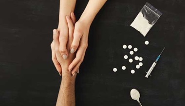 Drug user holds hands with someone to ask for help next to various substances.