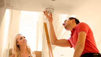 man changing a smoke detector