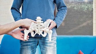 man holding sample pelvic bone